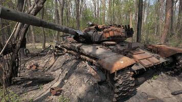 förstörd och bränt ut tank av de ryska armén som en resultat av de slåss med ukrainska trupper i de skog nära Kiev, ukraina. ryska aggression i ukraina. video