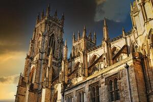 Majestic Gothic cathedral against a dramatic sky at sunset, showcasing intricate architecture and historical grandeur in York, UK. photo