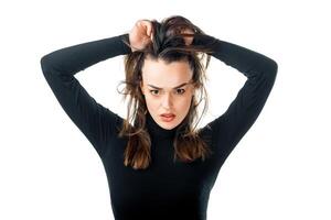 Attractive woman holding hair high above head. Happy and funny girl. Isolated white background. photo