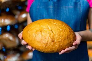 Bread in the hands of a baker. Hot bake from the oven. Industrial production of bread. Baker's hands with bread photo