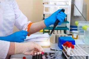 Hands of laboratory assistant in gloves analyzing blood sample. Prevention. Pneumonia diagnosing. COVID-19 and coronavirus identification. Pandemic. photo