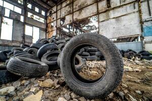 Tires that are no longer suitable for use on vehicles in a damaged plant. Rubber junk from the car. photo