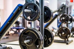 Pancakes on a dumbbell in a gym. Sport and healthy life concept. Set of pancakes on gym background. Sport equipment closeup. photo