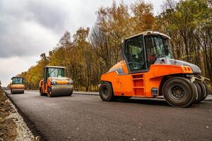 Road roller flattening new asphalt. Heavy vibration roller at work paving asphalt, road repairing. Selective focus. photo