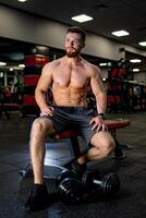 Handsome muscular bodybuilder have a rest after training. Shirtless strong man resting after an active workout. photo