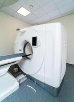MRI machine is ready to research in a hospital room. Selective focus on medic equipment. No people in clinic room photo