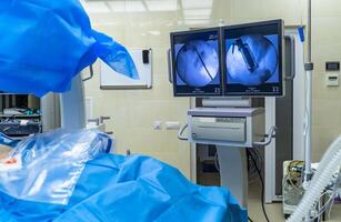 Process of surgery operation using laparoscopic equipment. Operating room with surgery equipment. Medical background. Monitoring the process on screen. photo