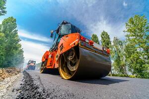 Heavy vibration roller at asphalt pavement works. Road repairing. photo