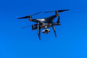 Quadrocopter with a professional camera flies in blue sky. Dron. photo