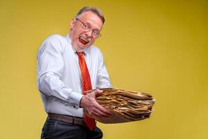 Manager in red tie giving big pile of documents over yellow background, cropped photo. photo