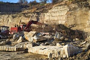 Stone crusher in a quarry. Mining industry. Repairing service on excavator photo