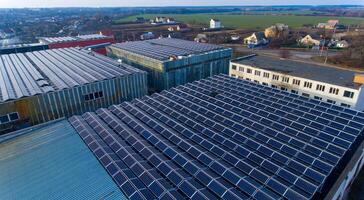 Lots of blue photovoltaic solar panels on the top of the building. Flat roof densely covered with solar batteries. View from the above. photo