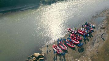 Antenne Aussicht von Rafting Vorbereitung auf Fluss Ufer, Gruppe von Sparren vorbereiten ihr Boote zum ein abenteuerlich Ausflug auf ein Flussufer. video