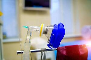 Oxygen mask as part of artificial lungs ventilation machine in surgery room, closeup. COVID-19 and coronavirus identification. Pandemic. photo