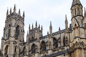 Gothic cathedral facade with intricate architecture and spires against a cloudy sky in York, North Yorkshire photo