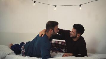 two men hugging each other while lying on a bed together video