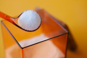 closeup of spoon pick salt from a container photo