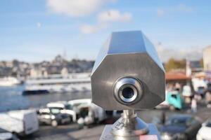 Coin-operated binoculars looking out over city , photo