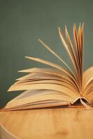 open book and a pencil on wooden table photo