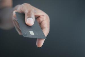 close up of person hand holding black color credit card photo