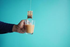 Cup of tea with tea bag on wooden table close-up. photo