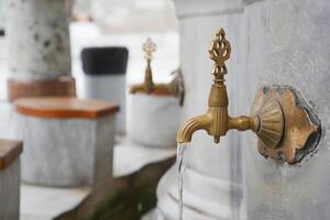water pouring from a faucet tap outdoor in istanbul photo