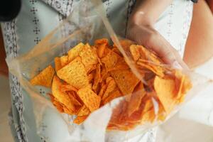 mujer mano recoger patata papas fritas desde un cuenco foto