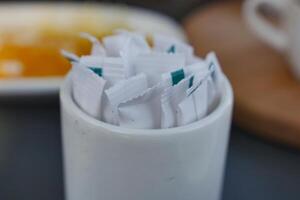 white sugar in a paper packet on table photo