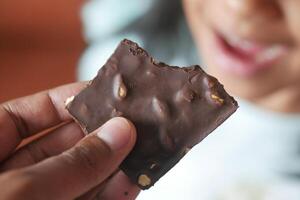 child eating dark chocolate close up photo