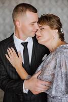 mother helps her adult son prepare for the wedding ceremony. An emotional and touching moment at a wedding. A mother hugs her son photo