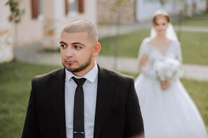 The moment of the first meeting of the bride and groom with a wedding bouquet, the bride goes to her lover in nature under the autumn sun. photo