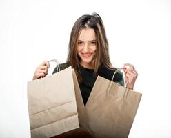 Young beauty is holding two grocery shopping bags on white background. Woman with brown paper bags. Isolated background. photo