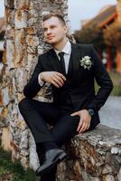 Portrait of a handsome young groom on an autumn day outdoors in an elegant suit. Outdoor photo. Handsome man in a business suit. photo