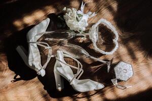 Bride's wedding ring on high-heeled shoes, women's perfume, wedding glasses. Wedding details. High quality photo