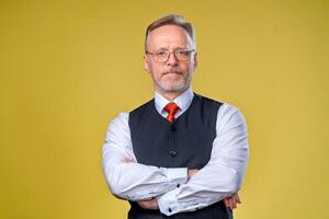 Confident senior man in shirt. Crossed arms on chest. Yellow background. Horizontal half length photo. photo