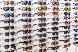 Sales rack of sunglasses. A colorful display of sunglasses for sale. Closeup. photo