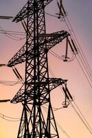 Electricity pylon on the background of sky. Big iron structure of high voltage. Selective focus from below. photo