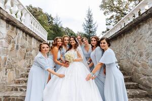 Wedding photography. A brunette bride in a white dress with a bouquet and her brunette girlfriends photo