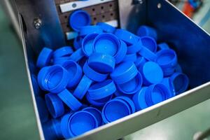 Bottling production. Plastic cups for bottles. Equipment at the dairy plant photo