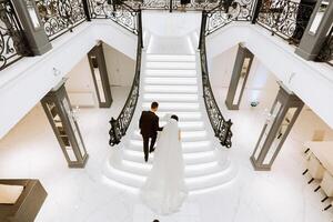 the bride and groom climb the stairs to celebrate the wedding, photo from above.