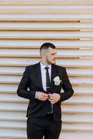 Portrait of a handsome young groom on an autumn day outdoors in an elegant suit. Outdoor photo. Handsome man in a business suit. photo