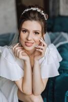 portrait of an incredibly beautiful girl bride in a white robe in the bedroom, the bride poses in the morning before the wedding ceremony. photo