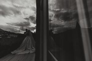 A handsome groom embraces his beloved in a beautiful location. Reflection in the mirror of the bride and groom. Wide format photo. photo