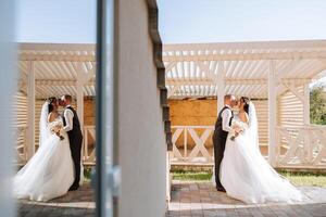 A handsome groom embraces his beloved in a beautiful location. Reflection in the mirror of the bride and groom. Wide format photo. photo