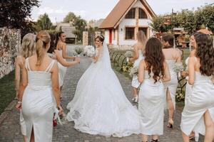 un morena novia en un largo Boda vestir y su amigos en beige vestidos foto