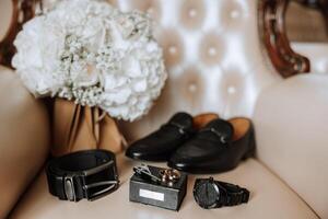 Men's accessories, groom details. Watch. Men's perfumes. Preparation for the wedding. Leather shoes. Gold wedding rings. bow tie Wedding bouquet of flowers. photo