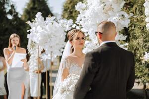 un hembra Boda presentador dando un habla y el novia y novio foto