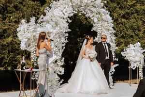 A female wedding presenter giving a speech and the bride and groom photo