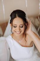 portrait of an incredibly beautiful girl bride in a white robe in the bedroom, the bride poses in the morning before the wedding ceremony. photo