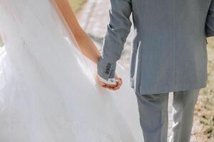 Together we make the world better. Closeup view of married couple holding hands. Bride and groom hand in hand photo